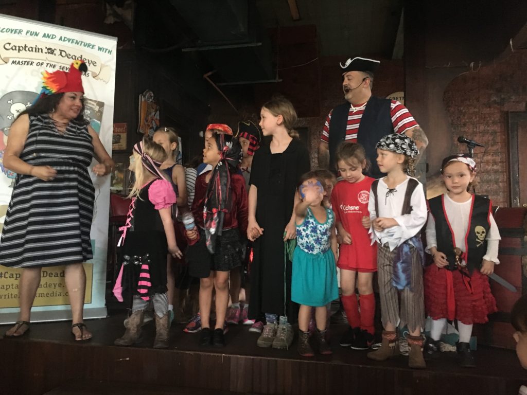 Dianne & John sing with children at the Family Pyrate Day in Algiers Point