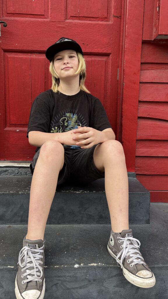 Arlo McCracken Allen on a stoop in front of a red door