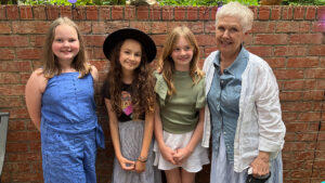Four musical friends in front of a red brick wall